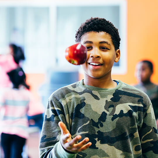 BGCMA youth holding up healthy apple
