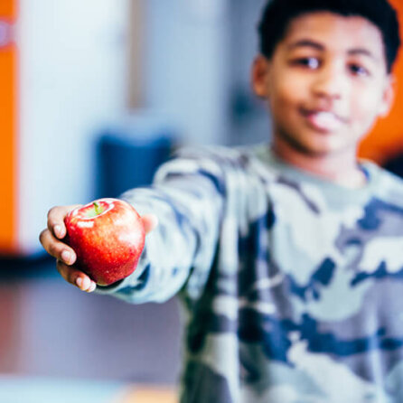 BGCMA youth holding up healthy apple